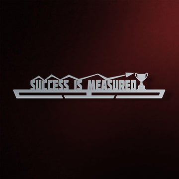 Success Is Measured Medal Hanger in laser-cut steel on a dark background